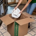 placing wrapped dish into kitchen moving box